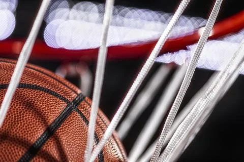 Looking up at the top of a basketball falling through the net with arena lights Foto stock