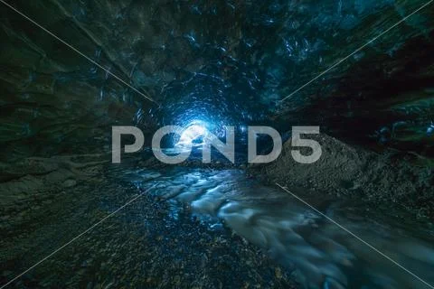 Looking toward the entrance of an ice cave while being 500 metres under a glacie Stock Photos