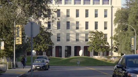 Looking towards Mrak Hall on the UC, Davis campus. Traffic goes by. Stock Footage 72505869