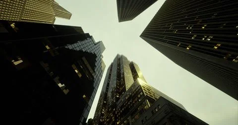 Looking up at towering skyscrapers beneath a cloudy sky during twilight Stock Illustration