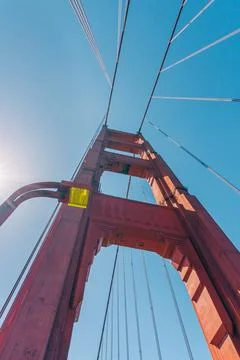 Looking up at the towering structure of the Golden Gate Bridge against the sk Stock Photos