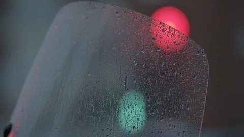 Looking at traffic lights through wet motorcycle windscreen Stock Footage 124621549