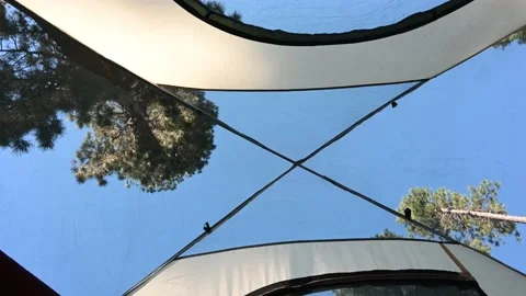 Looking up trough a tent at the sky and trees Stock Footage 135707943