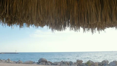 Looking Under a Thatched Umbrella to the Ocean Horizon with Space for Text Stock Footage 101201778