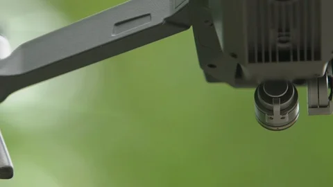 Looking up on the underbelly and camera of a hovering drone in slow motion Stock Footage 90050108