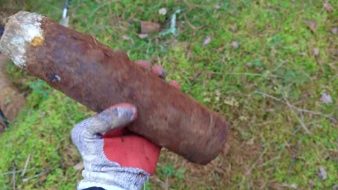 Looking at an Unearthed Unexploded WW2 Artillery Shell in Hand Stock Footage 292284811