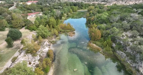 Looking at a very clear river and rocks on the bottom early fall Stock Footage 221115639