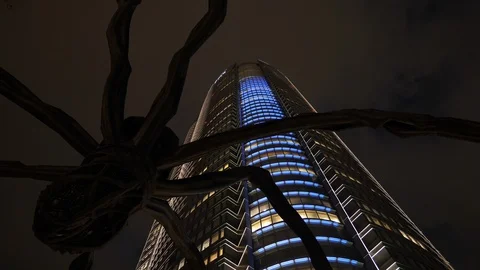Looking up view of Mori Building and spider sculpture Maman Stock Footage 103554299