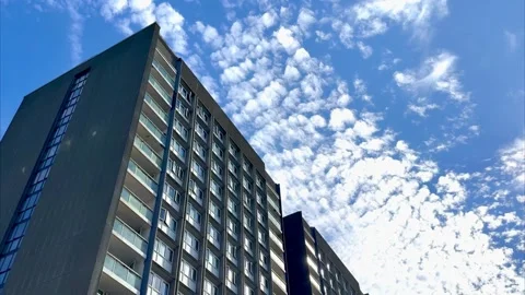 Looking up view of urban block of council flats blue sky and clouds background Stock Footage 317444643