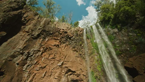 Looking up at waterfall spilling over rocks in state forest Stock Footage 152802292