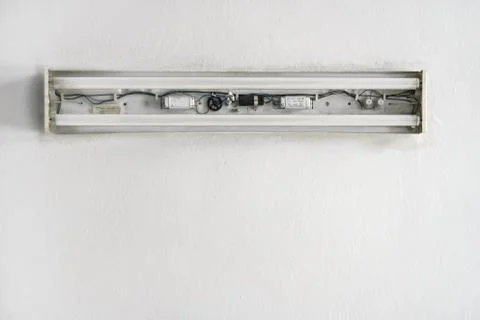Looking up white ceiling in room, old neon lamp with no cover, cables and inside Foto stock