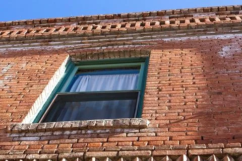Looking up at a window in an old brick building, Jerome, Arizona. Stock Photos
