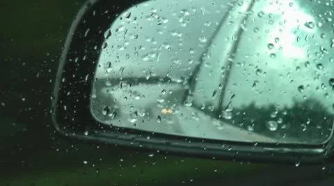 Looking into wing mirror of silver car travelling on motorway in the rain Stock Footage 12180103