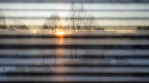 Looking at winter sunset through office window closed by blinds, walk Stock Footage 129574452