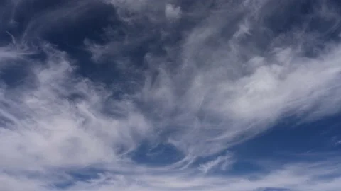 Looking up at wispy white clouds moving through a blue sky Stock Footage 219484646
