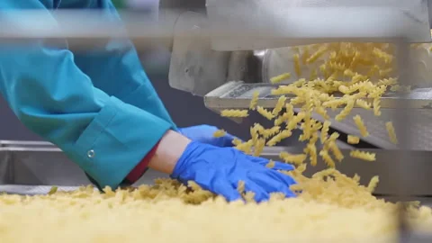 Looking on the worker hands in blue gloves that controls quality of a pasta Stock Footage 162501258