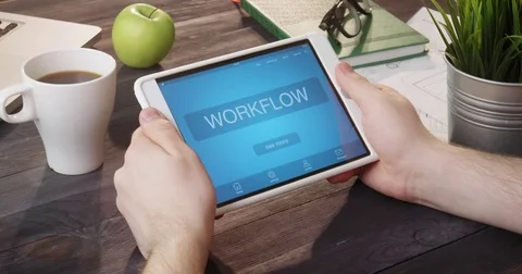 Looking at workflow info using digital tablet at desk Stock Footage