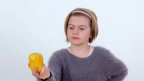 Looking at a yellow pepper in her hand Stock Footage 83724733