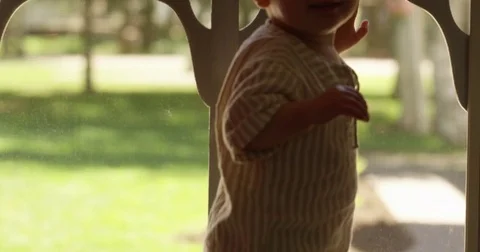 Looking at young boy in front of screen door - tilt up shot Stock Footage
