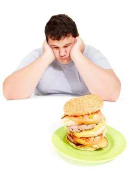 That looks like another 5 pounds. A dejecting young obese man holds his head in Stock Photos