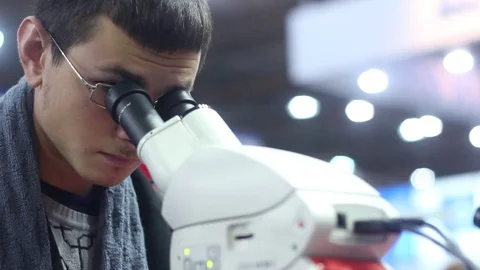 Looks into the modern laboratory microscope Stock Footage 73387417