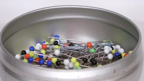 Loop able footage of many pins with coloured glass heads on a white backgroun Stock Footage 168365395