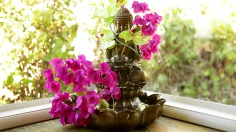 Loop: Buddha fountain in window with pink flowers - wide Stock Footage 22025332