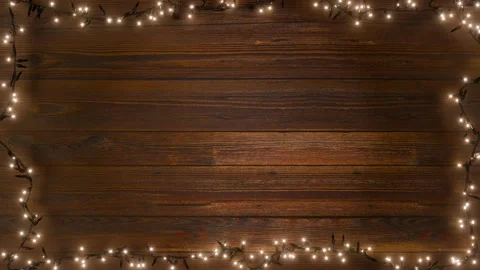 A loop of Christmas lights is framed against a rustic wooden backdrop. Stock Footage 322650077