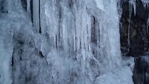 Loop closeup of melting icicles on rock face Stock Footage 82624207