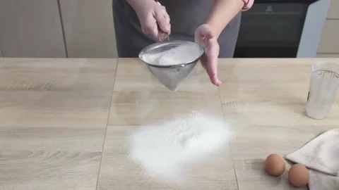 Loop. cook in kitchen pours wheat flour into metal strainer and sifts 스톡 동영상 140470827