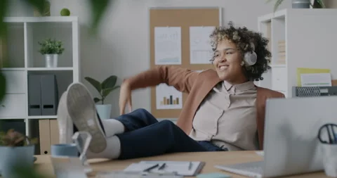 Loop of creative African American employee dancing relaxing in office listening Stock Footage 275596356