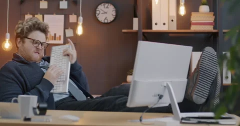 Loop of creative young businessman having fun in office playing the guitar with Stock Footage 276439674