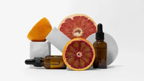 Loop of dropper glass bottles with grapefruit, orange on pedestal stop motion Stock Footage 152877964