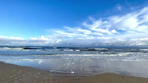 Loop features foamy gentle waves breaking on a sandy beach Stock Footage 297613014