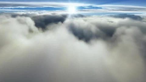 (loop) Flying through majestic clouds with the sun shining making rays Stock Footage 247604390
