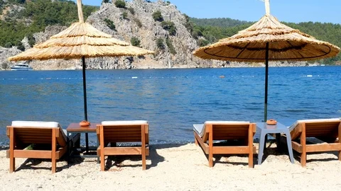 Loop footage of a beach with two umbrellas and beach chairs Stock Footage 113823950