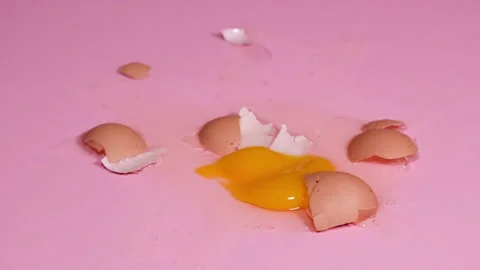 Loop HD video of the chicken egg falling and braking on pink background. 4k Stock Footage 273183325