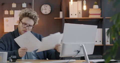 Loop of overworked businessman reading documents looking at papers sitting at 스톡 동영상 275594308