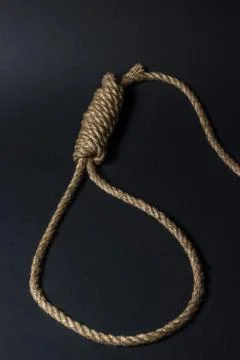 Loop from a rope on a black background. Social problem.  Stock Photos