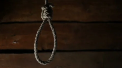 A loop of rope hangs against a wooden wall in an old abandoned house Stock Footage 130734589
