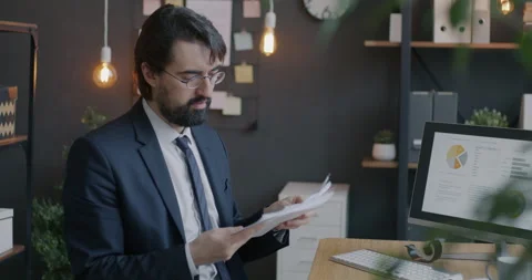 Loop of serious Middle Eastern businessman reading documents holding papers 스톡 동영상 276356186