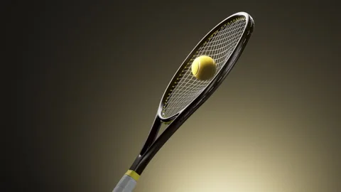 Loop Tennis ball captured against racket strings under dramatic studio light Stock Footage 347895015