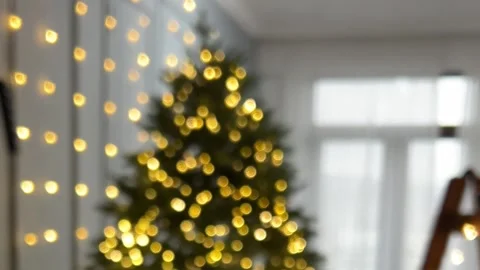 Loop video. Garland on Christmas tree is out of focus at apartment room Video stock 343683700