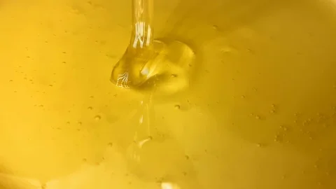 Loop video. Golden syrup dripping from a spoon into a glass container. Sweet hon Video stock 114454547