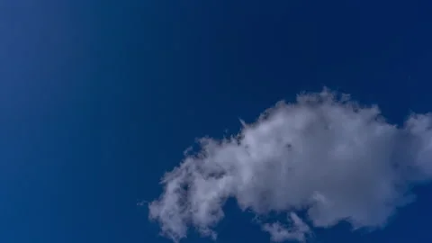 Loopable 4k Uhd speed timelapse of white fluffy clouds passing rapidly on high c Stock Footage 265859719