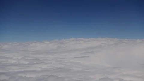 Loopable Camera travels smoothly above soft, fluffy clouds high in the sky Stock Footage 329358703
