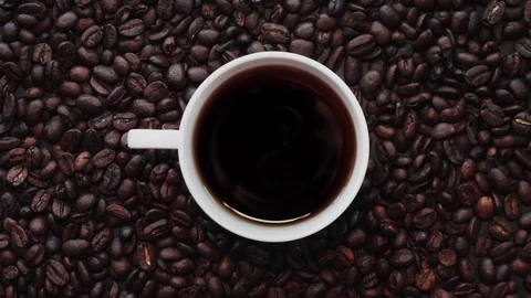 Loopable Cinemagraph of Cup of Coffee among Coffee Beans. Top View Stock Footage 102266530