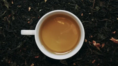 Loopable Cinemagraph of Cup of Green Tea among Dry Tea Leaves. Top View Stock Footage 102266598