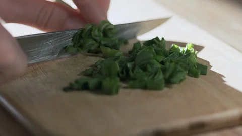 Loopable clip of woman cutting green onion on the kitchen with knife, close up Vídeo Stock 129797718