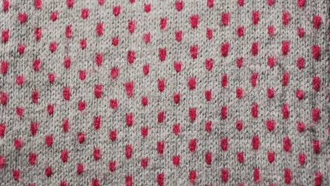Looped, abstract texture, pattern. Knitted gray fabric with red dots. Warm scarf Video stock 101617846